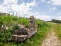 geschnitzter Brunnen am Wegesrand